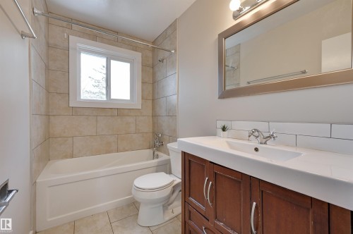 The property features a bathroom with a white bathtub, a toilet, and a window - 13211 104 Street, Edmonton, AB - Indoor Photo Showing Bathroom