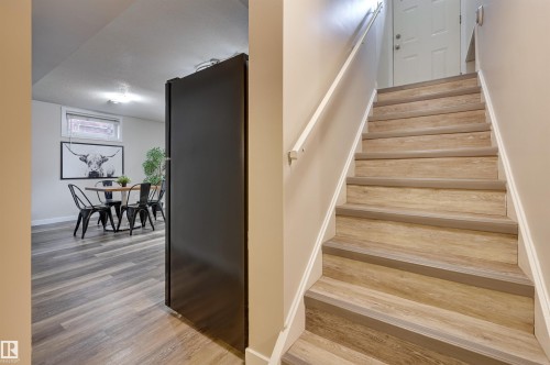The property features a staircase with light wood-style treads and white risers, equipped with a white handrail - 13211 104 Street, Edmonton, AB - Indoor Photo Showing Other Room
