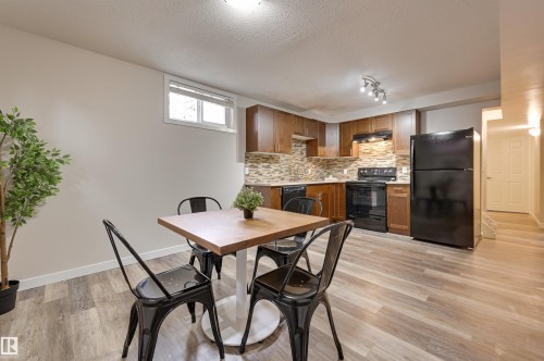 The kitchen and dining area features wood flooring, a window providing natural light, and recessed lighting - 13211 104 Street, Edmonton, AB - Indoor