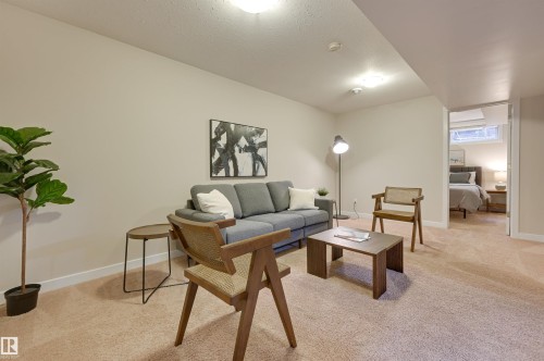 Living area featuring light-colored carpeting and walls, overhead lighting, and a doorway leading to an additional room - 13211 104 Street, Edmonton, AB - Indoor