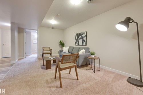 The property features neutral-toned walls, recessed lighting, and soft carpeting throughout the main area - 13211 104 Street, Edmonton, AB - Indoor Photo Showing Other Room