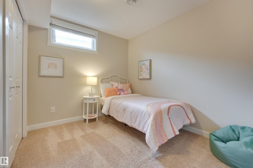 This room features neutral-toned walls, carpeted flooring, and a window providing natural light - 13211 104 Street, Edmonton, AB - Indoor Photo Showing Bedroom