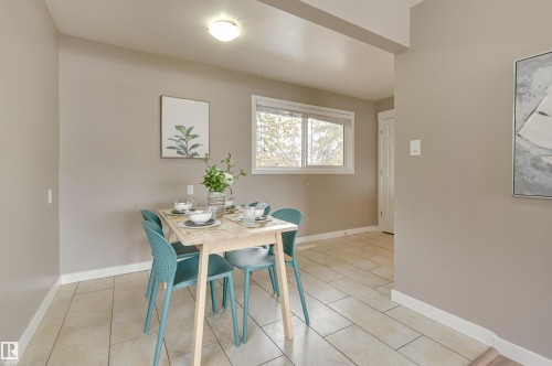 Dining area featuring light-colored tile flooring, a window providing natural light, and neutral wall tones - 13211 104 Street, Edmonton, AB - Indoor Photo Showing Dining Room