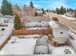 The property features a fenced yard with a detached garage and an additional shed - 