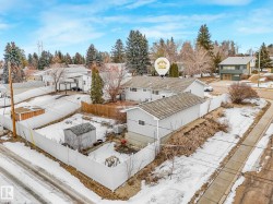 The property includes a fenced yard, a detached garage, and an additional shed - 