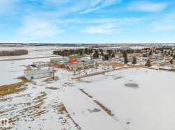 Aerial view showcasing the property's location within a community, surrounded by open, snow-covered fields and distant tree lines - 