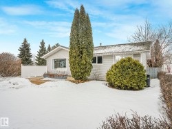 The property features a white exterior with visible windows, a white fence, and a pitched roof - 