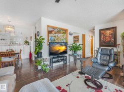 The living area features wood-look flooring and white walls, offering a bright and inviting atmosphere - 