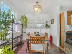Dining area featuring hardwood floors, a crystal chandelier, and a built-in display cabinet - 