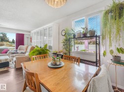 The dining area features wood flooring and a wooden table with chairs - 