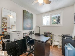 This versatile room features a large window providing natural light, a ceiling fan, and durable wood-look flooring - 