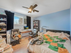 The room features light blue walls, a ceiling fan, and a window providing natural light - 