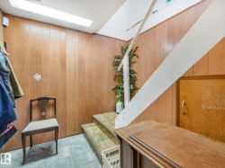 The property features wood-paneled walls and a staircase with white stringers and risers - 