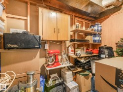Storage area featuring wood paneling, wood shelving, and wood cabinetry - 