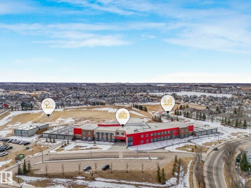 Aerial view showcasing the expansive community, featuring numerous houses, a school, and surrounding open spaces - 8112 Summerside Grande Boulevard, Edmonton, AB - Outdoor With View