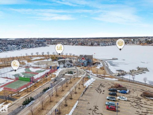 Aerial view showcasing the property's proximity to a tennis court, a community building, and a frozen body of water with a dock - 8112 Summerside Grande Boulevard, Edmonton, AB - Outdoor With Body Of Water With View