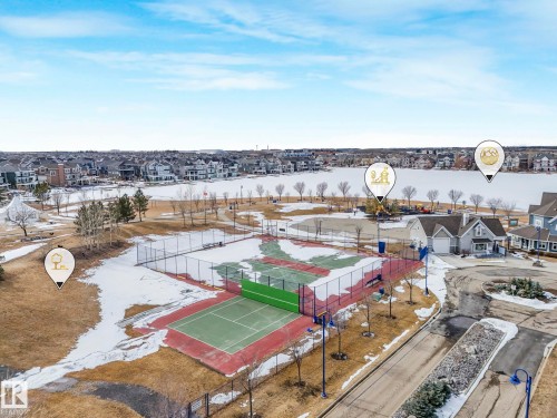 Aerial view of the community, showcasing a tennis court, a paddle tennis court, and a frozen body of water - 8112 Summerside Grande Boulevard, Edmonton, AB - Outdoor With View