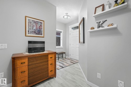 The entry hallway features light-colored flooring, a white paneled door with glass inserts, and recessed lighting - 8112 Summerside Grande Boulevard, Edmonton, AB - Indoor