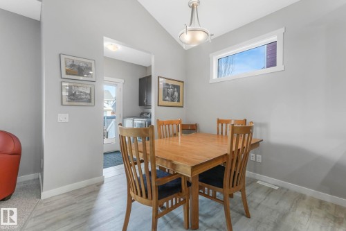 This dining area features a vaulted ceiling with a hanging light fixture and light-colored flooring - 8112 Summerside Grande Boulevard, Edmonton, AB - Indoor Photo Showing Dining Room
