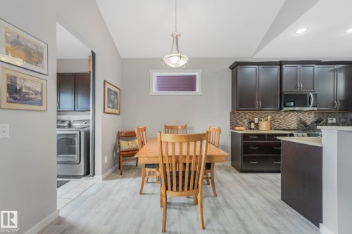 The dining area features light-toned flooring, a window providing natural light, and a ceiling light fixture - 8112 Summerside Grande Boulevard, Edmonton, AB - Indoor