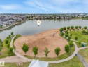 Aerial view showcasing a sandy beach area with volleyball nets, surrounded by green spaces and pathways - 8112 Summerside Grande Boulevard, Edmonton, AB  - Outdoor With Body Of Water With View 