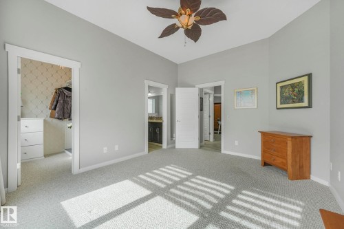 Spacious room featuring light gray walls, plush carpet flooring, and a decorative ceiling fan - 8112 Summerside Grande Boulevard, Edmonton, AB - Indoor