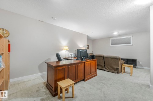 This versatile room features light-colored carpeting, a window, and recessed lighting - 8112 Summerside Grande Boulevard, Edmonton, AB - Indoor Photo Showing Office