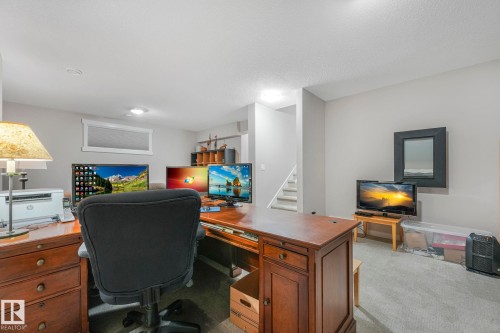 The property includes a spacious room with light gray walls, light gray carpet, and recessed lighting - 8112 Summerside Grande Boulevard, Edmonton, AB - Indoor Photo Showing Office