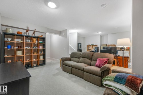 This spacious room features light-colored carpet flooring and light gray walls - 8112 Summerside Grande Boulevard, Edmonton, AB - Indoor Photo Showing Living Room