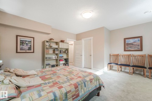 This room features light-colored carpeting, a ceiling-mounted light fixture, and two doors - 8112 Summerside Grande Boulevard, Edmonton, AB - Indoor Photo Showing Bedroom