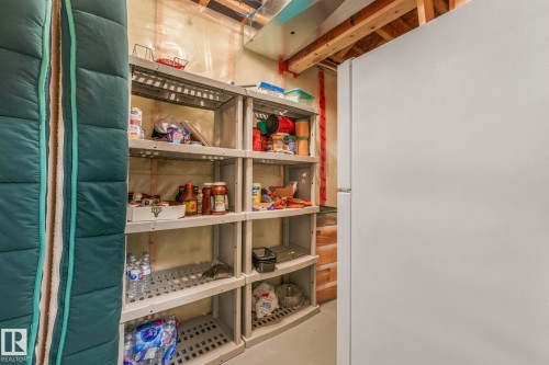 The property features an additional white refrigerator and extensive shelving for storage - 8112 Summerside Grande Boulevard, Edmonton, AB - Indoor With Storage