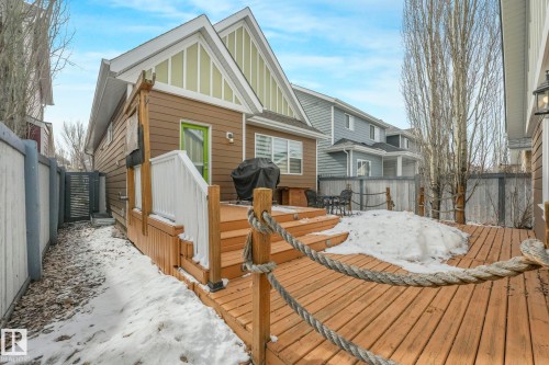 The property features a wooden deck with railing, a rope detail, and steps leading to the yard - 8112 Summerside Grande Boulevard, Edmonton, AB - Outdoor With Deck Patio Veranda