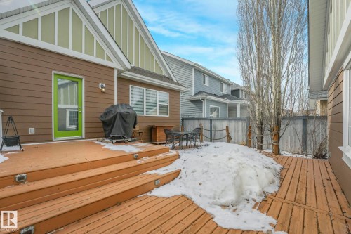 The property features a private wooden deck with steps, a bright green door, and a wooden fence - 8112 Summerside Grande Boulevard, Edmonton, AB - Outdoor With Deck Patio Veranda With Exterior