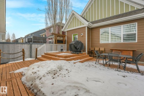 The property features a multi-level deck with white railings, a wooden walkway, and a fenced yard - 8112 Summerside Grande Boulevard, Edmonton, AB - Outdoor With Deck Patio Veranda With Exterior