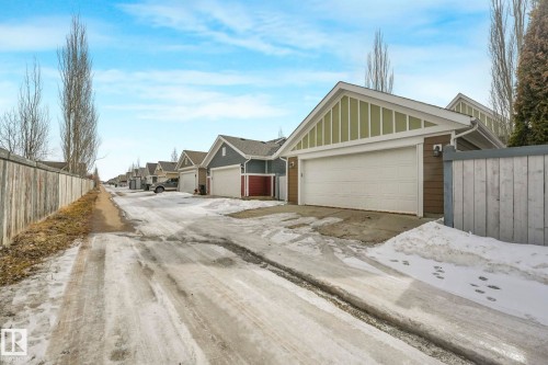 The property features an attached garage with a white garage door, and brown and green siding - 8112 Summerside Grande Boulevard, Edmonton, AB - Outdoor