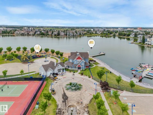 Aerial view showcasing the lakeside property with a private dock and nearby recreational facilities including tennis courts and a beach area - 8112 Summerside Grande Boulevard, Edmonton, AB - Outdoor With Body Of Water With View