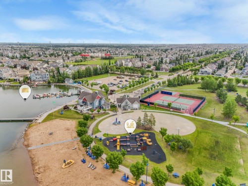 Aerial view showcasing the community with a lake, sandy beach area, and tennis courts - 8112 Summerside Grande Boulevard, Edmonton, AB - Outdoor With View