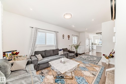 Living area featuring hardwood flooring, recessed lighting, and a large window. - 12435 47 Street Nw, Edmonton, AB - Indoor Photo Showing Living Room