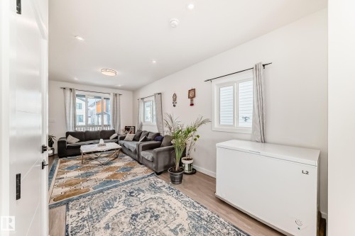 The living area features light wood-style flooring, white walls, and recessed lighting. - 12435 47 Street Nw, Edmonton, AB - Indoor