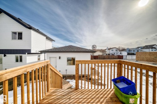 The property features a wooden deck with railing, providing outdoor space and ease of access to the double car garage. Landscaping will be done by the builder in the spring of 2026. - 12435 47 Street Nw, Edmonton, AB - Outdoor With Deck Patio Veranda With Exterior