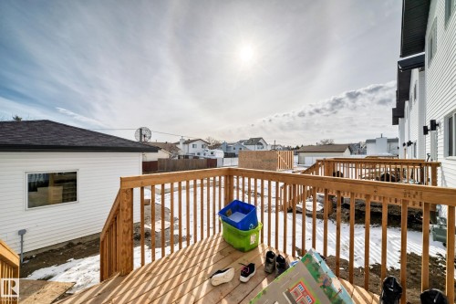 This property features a wooden deck with railings, providing an outdoor living space - 12435 47 Street Nw, Edmonton, AB - Outdoor With Deck Patio Veranda With Exterior
