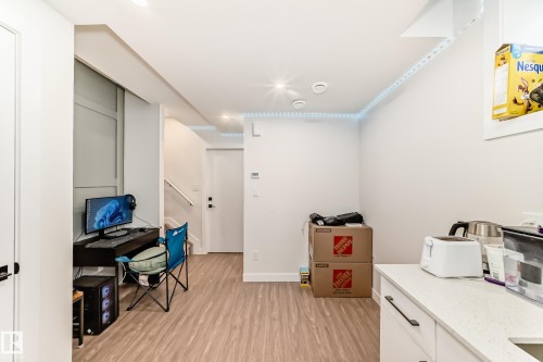 This space features light-toned flooring and white walls, creating a bright and airy atmosphere - 12435 47 Street Nw, Edmonton, AB - Indoor Photo Showing Other Room