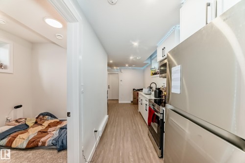 Kitchen featuring a stainless steel refrigerator, stainless steel range, and white cabinetry - 12435 47 Street Nw, Edmonton, AB - Indoor