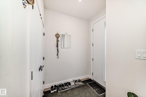 This entryway features white walls, a white door , closet space and entry to the LR. - 12435 47 Street Nw, Edmonton, AB - Indoor Photo Showing Other Room