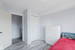 This room features light blue walls, light-toned wood-style flooring, a white bi-fold closet door, and a white interior door - 