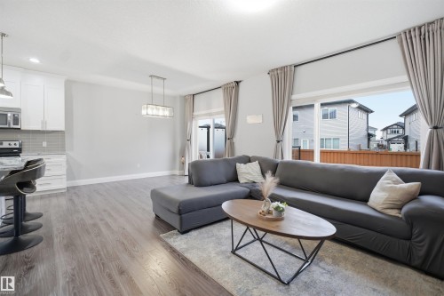 This property features an open-concept living area with light-toned flooring and a spacious sliding glass door that provides access to the outdoors - 8424 Cushing Court, Edmonton, AB - Indoor Photo Showing Living Room