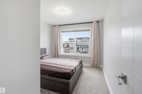 This room features light gray walls, a window with curtains, and carpeting - 8424 Cushing Court, Edmonton, AB - Indoor Photo Showing Bedroom