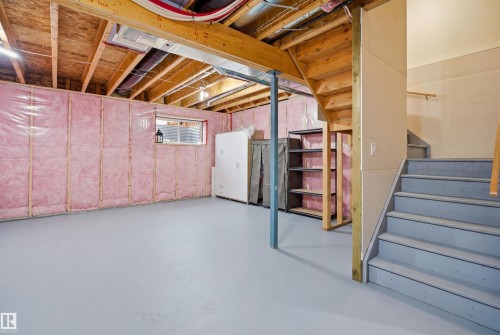 This unfinished basement features exposed wooden ceiling beams, insulated walls, and a concrete floor - 8424 Cushing Court, Edmonton, AB - Indoor Photo Showing Basement