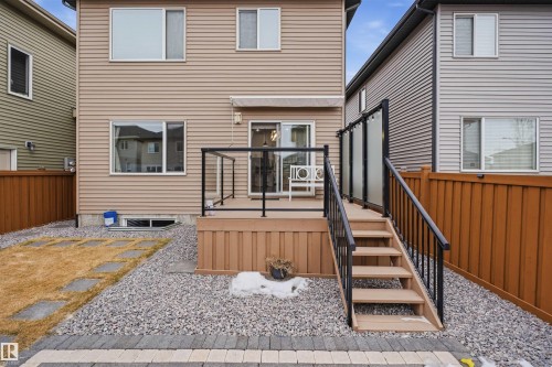 The property features a rear exterior with siding, a raised deck with stairs, and a fenced yard - 8424 Cushing Court, Edmonton, AB - Outdoor With Exterior