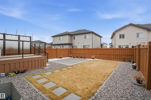 The property features a spacious yard with a deck, a paved patio area, and a lawn - 8424 Cushing Court, Edmonton, AB - Outdoor